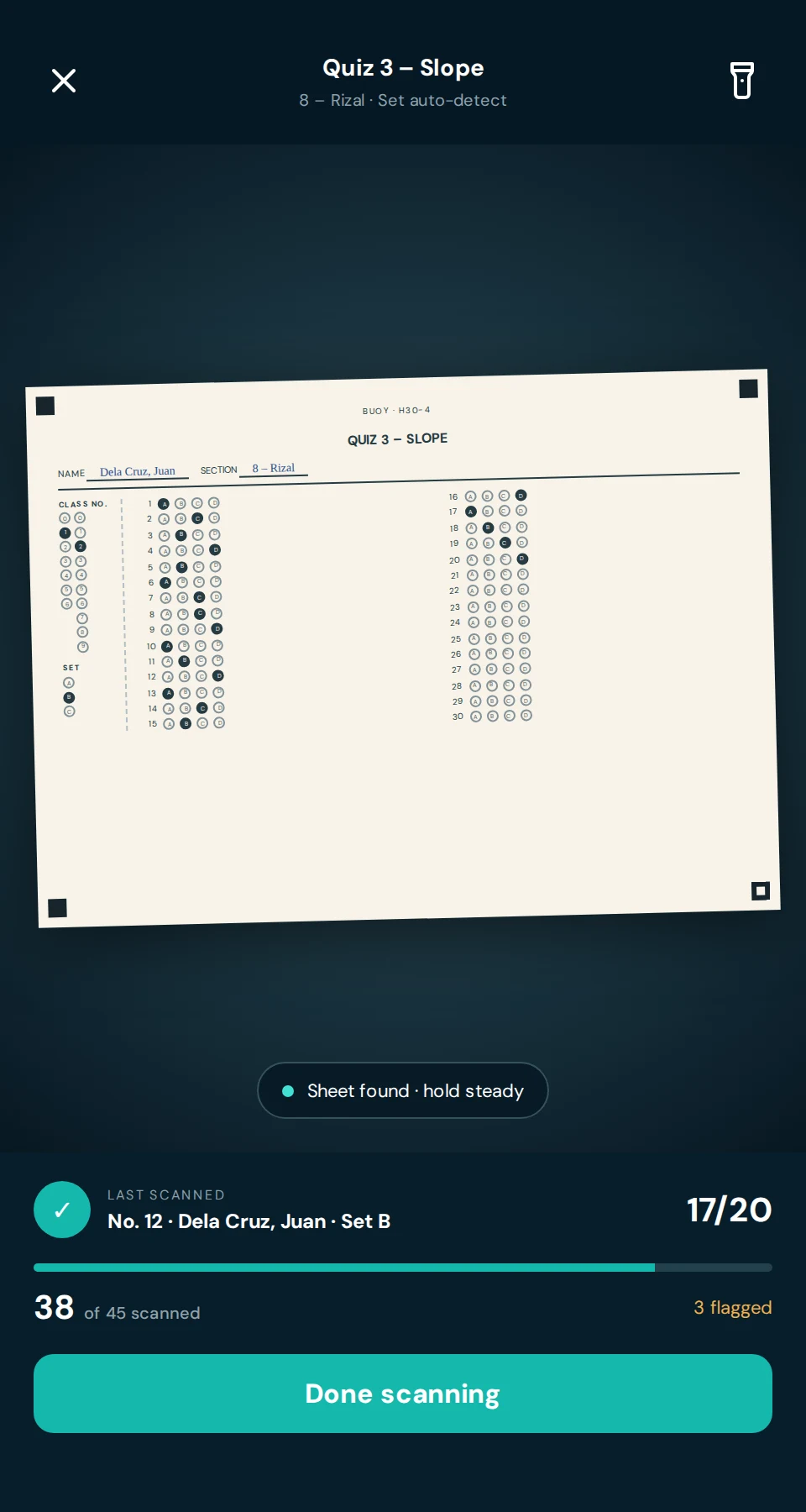 The scanner holding an answer sheet in view, with the count of papers scanned and flagged.